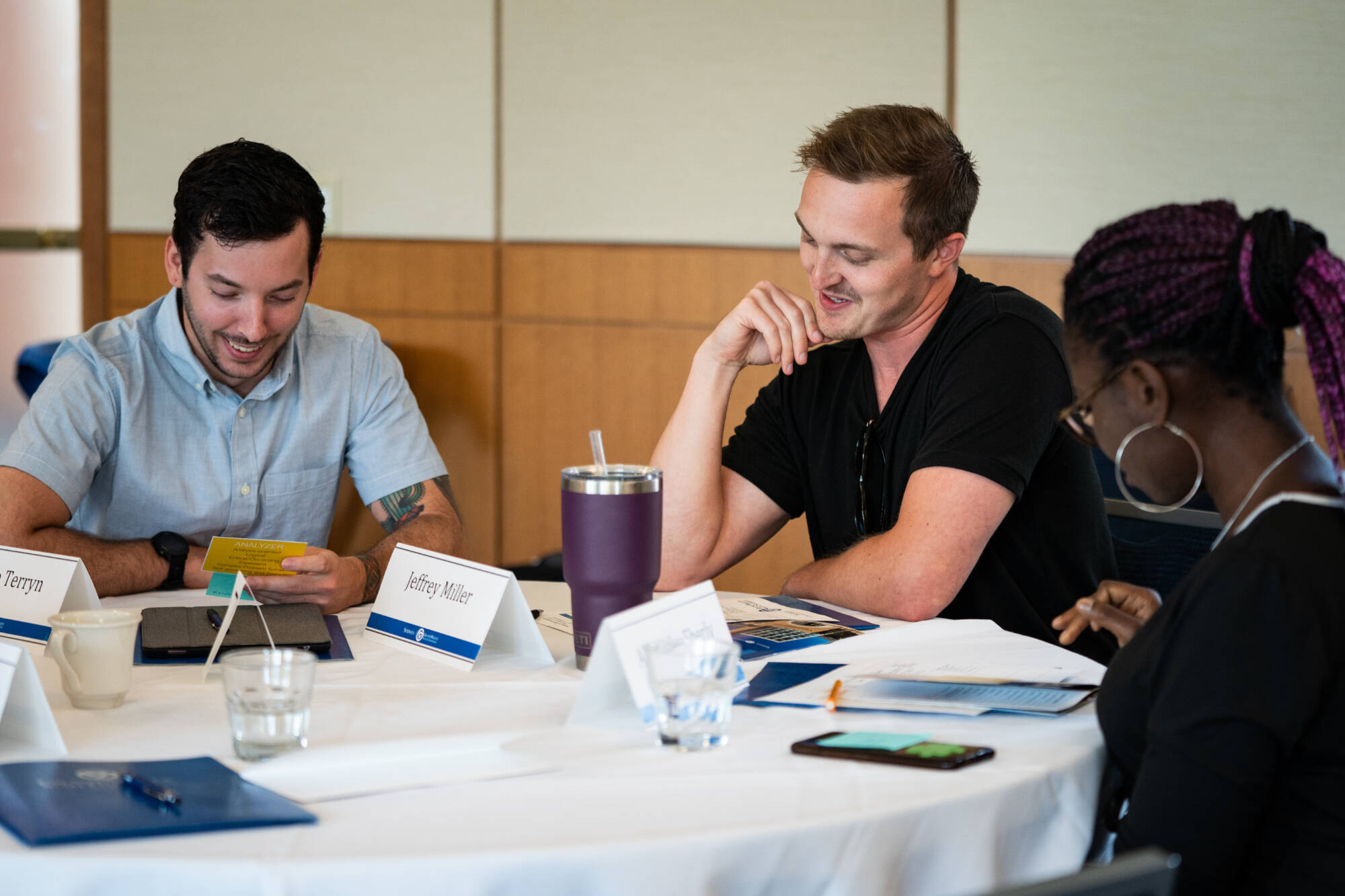 Three students working at a table in the Loosemore Forum